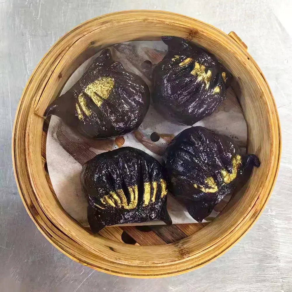 Four black buns with gold patterns in steamer at Easy Joy Hot Pot Dim Sum Buffet，a Chinese Restaurant in New York
